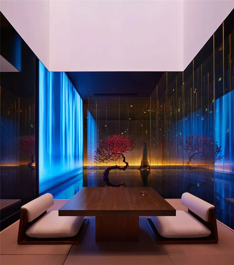 Seating within blue-lit glass room