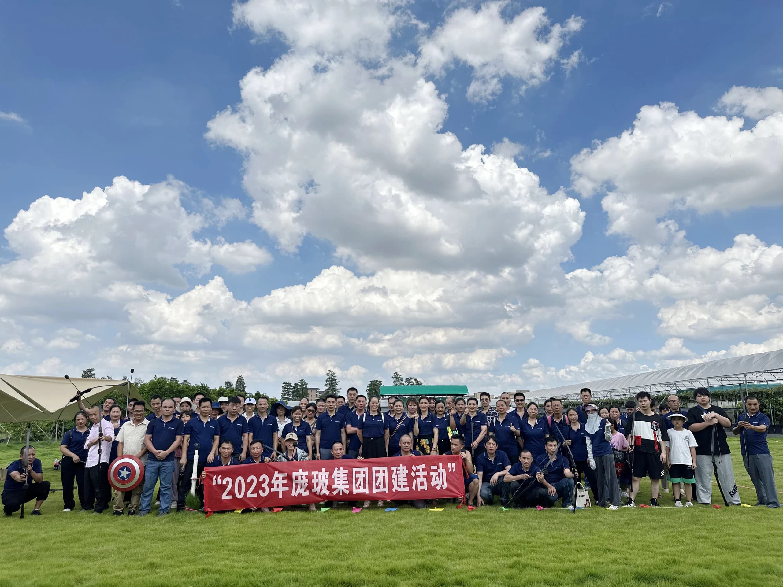 POBO group gathering outdoors beneath a 2023 team activity banner