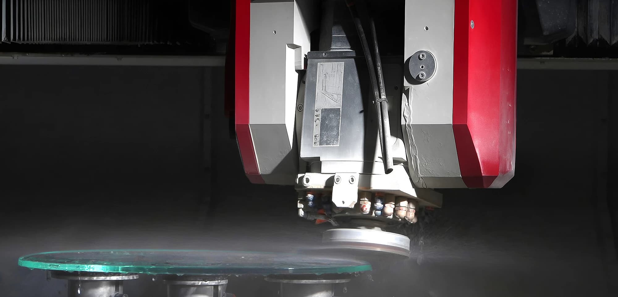 Machining head working at the edge of a glass panel