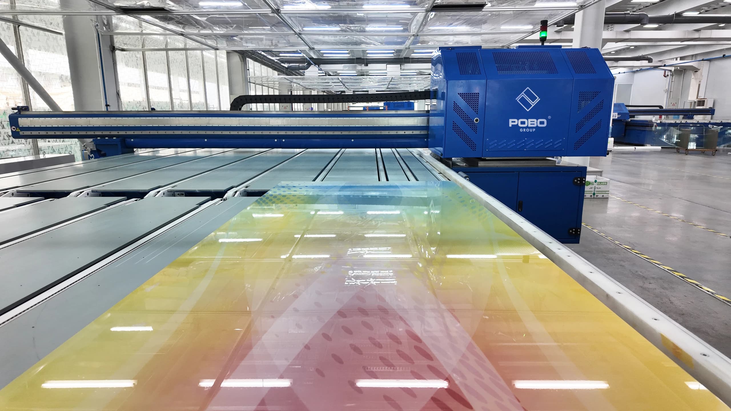 Decorative glass passing beneath a POBO printing unit