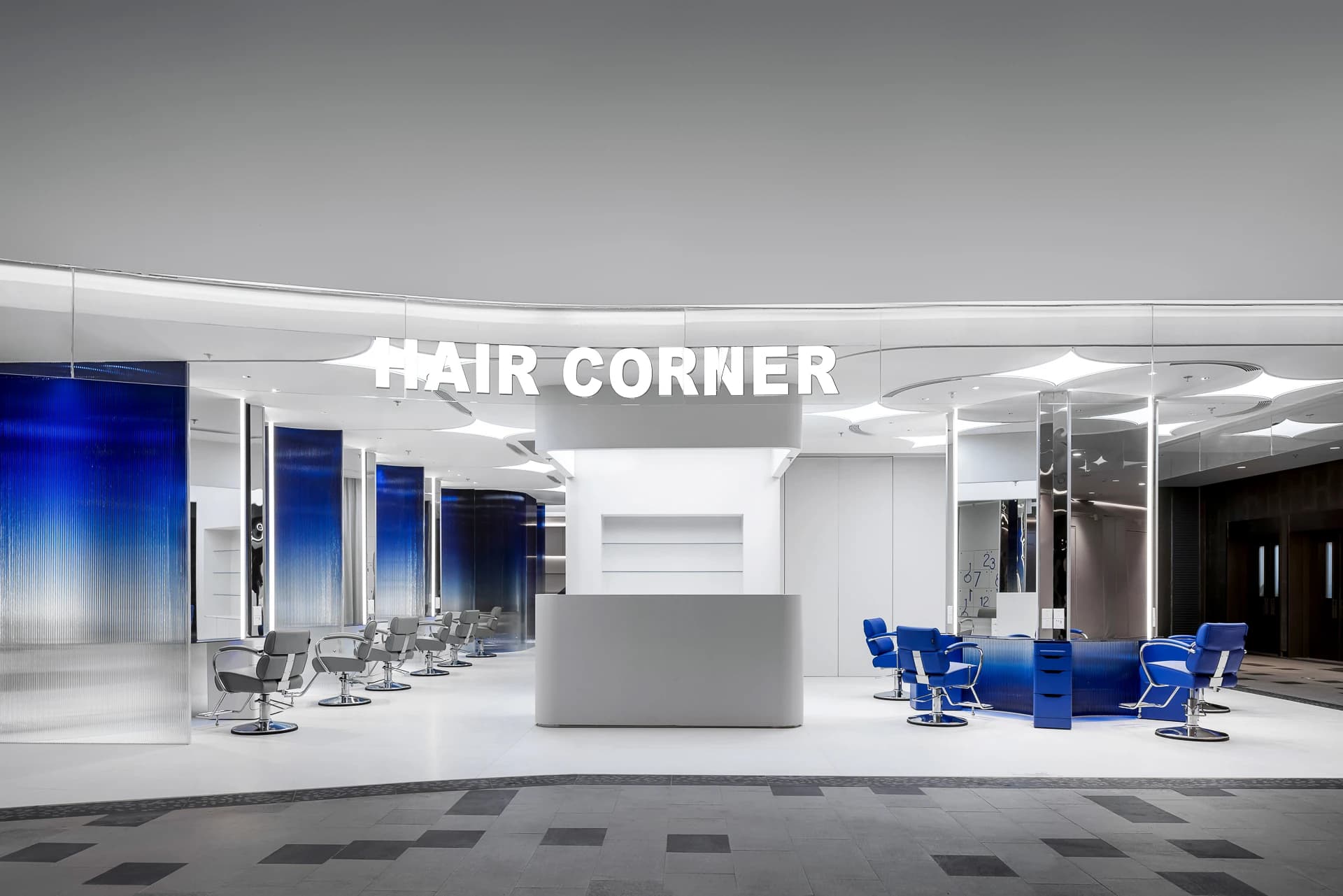 A bright salon interior divided by blue gradient glass screens