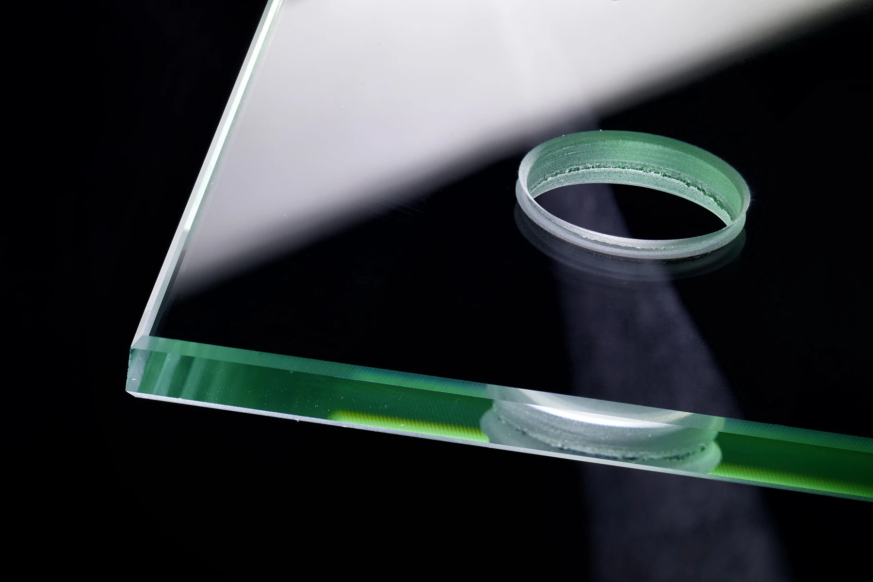 A precisely drilled circular opening through a thick glass panel