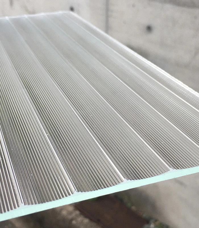 Light tracing the fine ribs of a textured glass panel
